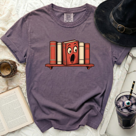 Purple t-shirt with a shocked cartoon book graphic on a shelf.