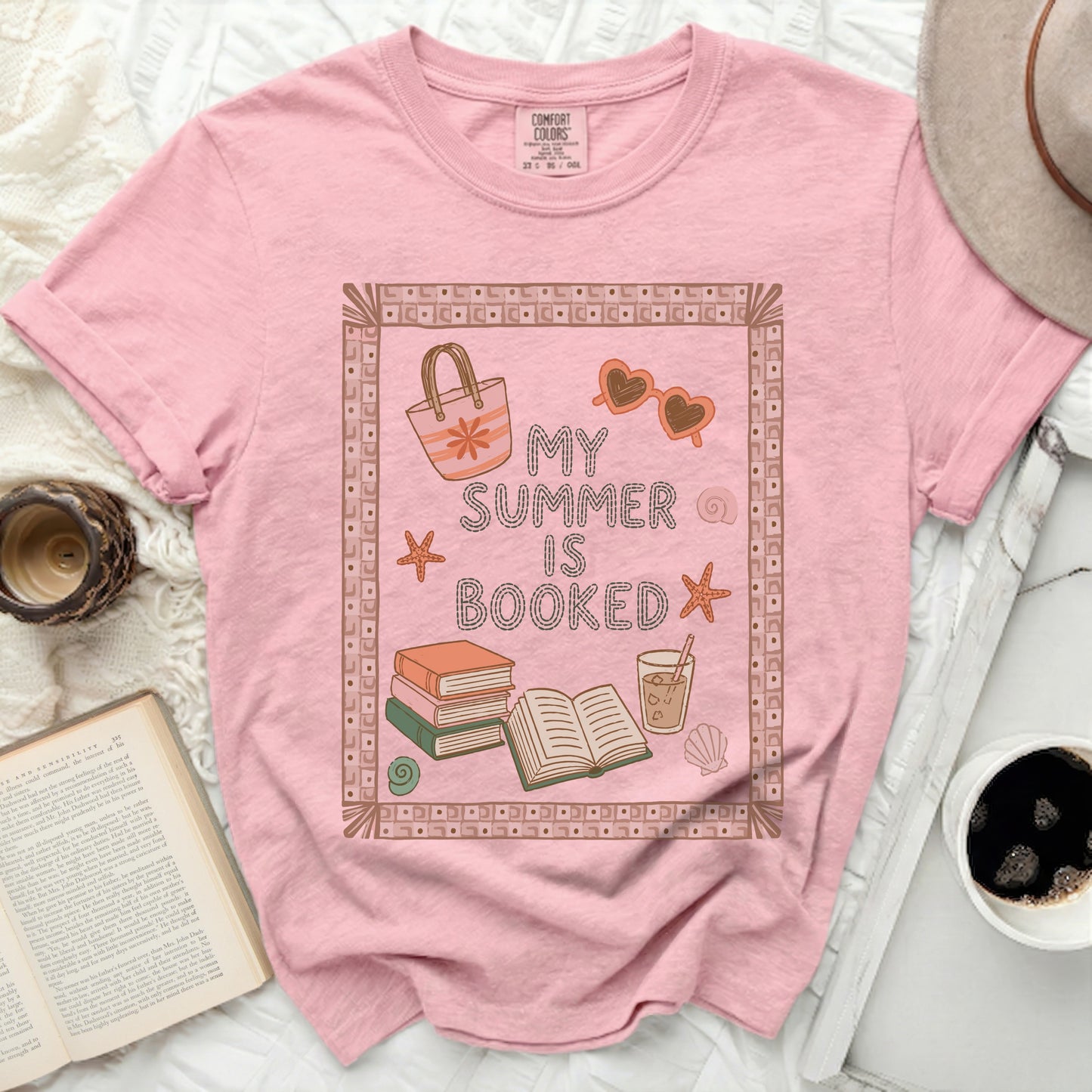 Pink t-shirt with "My Summer is Booked" and beach graphics.