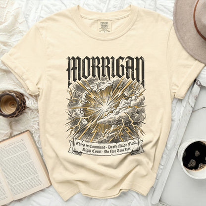 Cream t-shirt with black and gold "Morrigan" graphic and text.