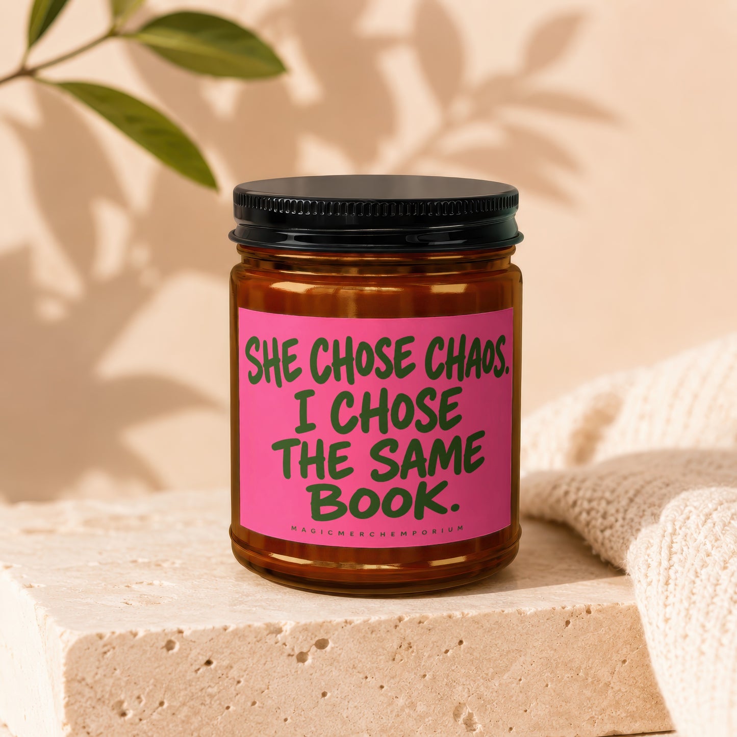 Candle with text "SHE CHOSE CHAOS. I CHOSE THE SAME BOOK."