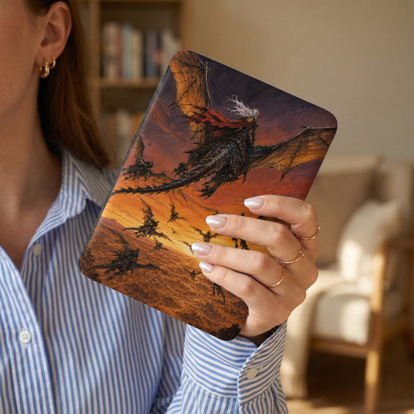 Dragon artwork design on a tablet held by a woman in a striped shirt.