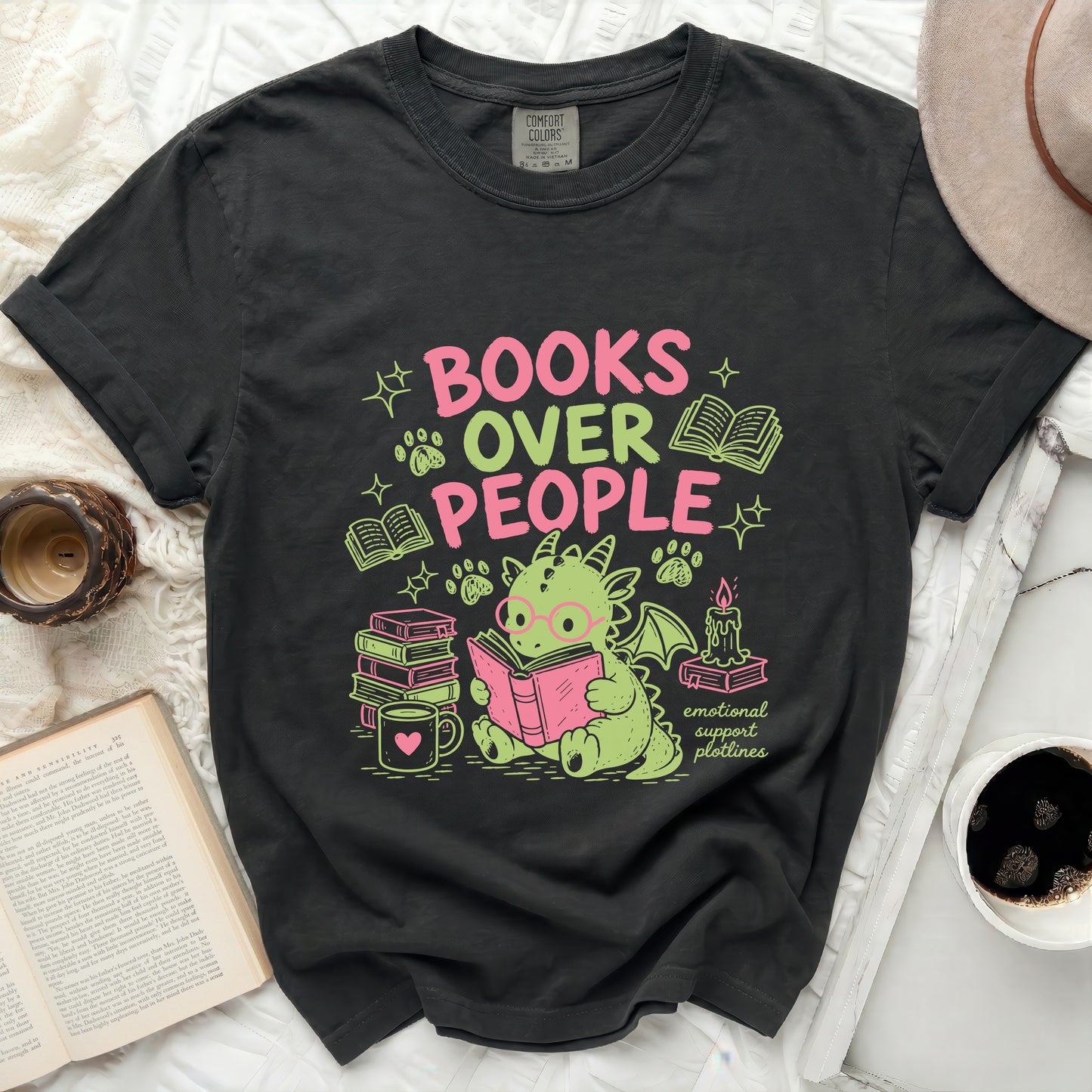 Dragon reading "Books Over People" surrounded by books, candle, and paw prints.