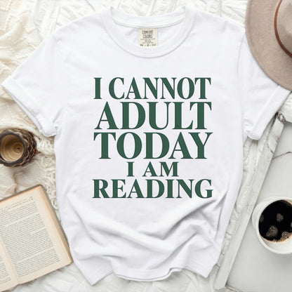 White t-shirt with "I CANNOT ADULT TODAY I AM READING" in green text.