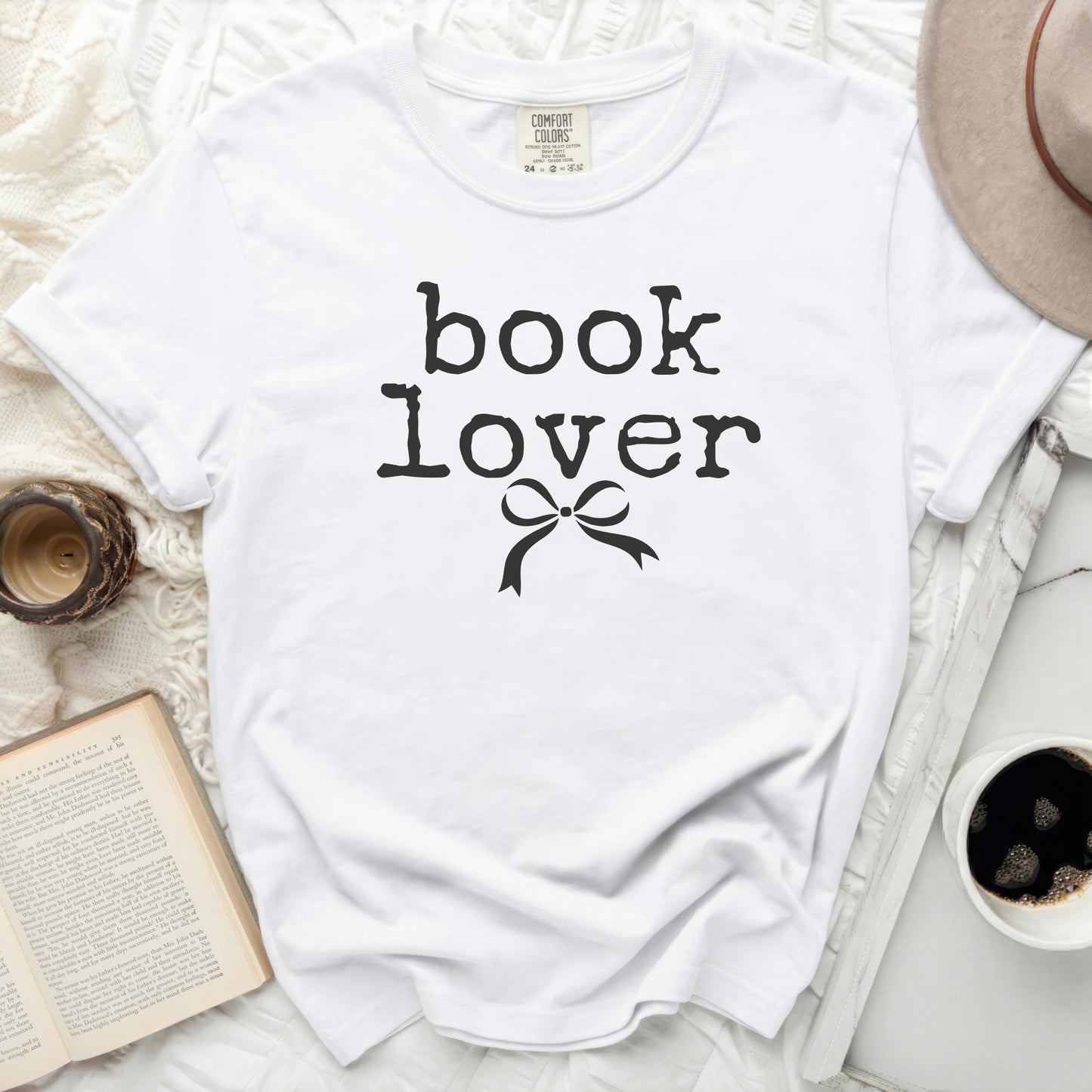 White t-shirt with black "book lover" text and bow graphic.