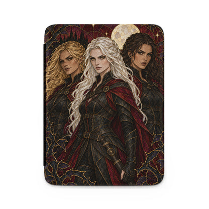 Three women in ornate armor stand before a moonlit castle and thorny vines.