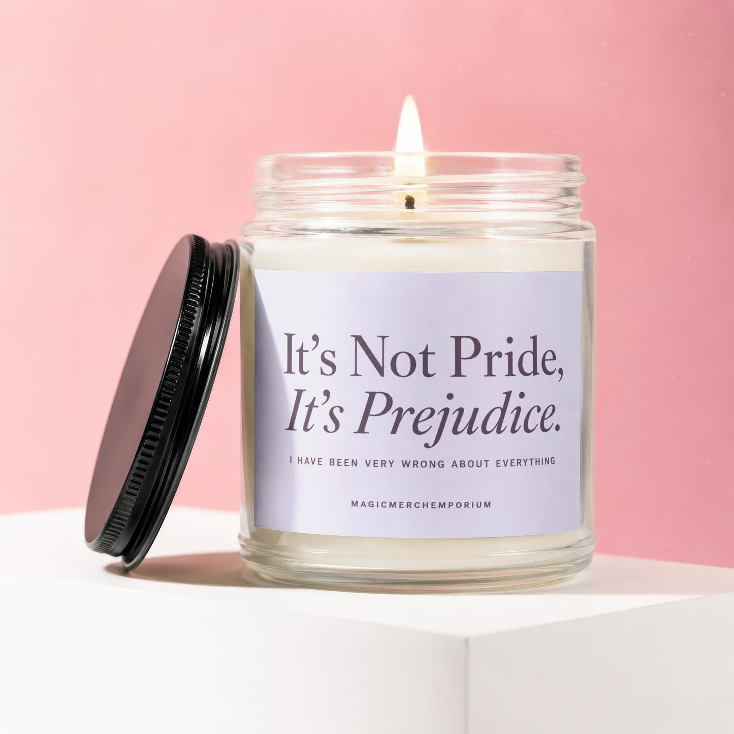 Candle with "It's Not Pride, It's Prejudice" label and a lit wick.