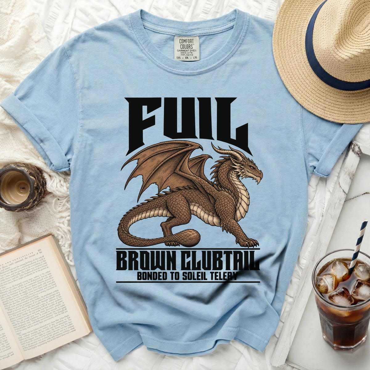 Light blue t-shirt with a brown dragon graphic and text: "FUL", "BROWN CLUBTAIL", "BONDED TO SOLEIL TELERY".