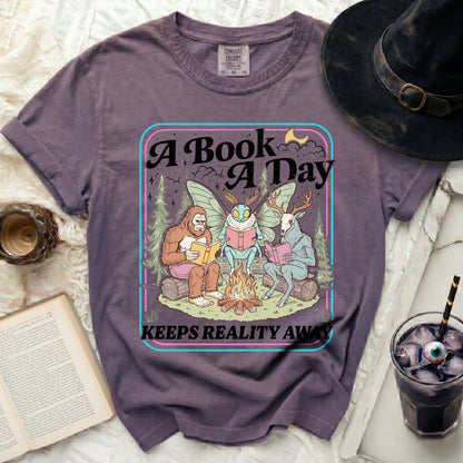 Bigfoot, moth, and deer read books around a campfire. "A Book A Day Keeps Reality Away."
