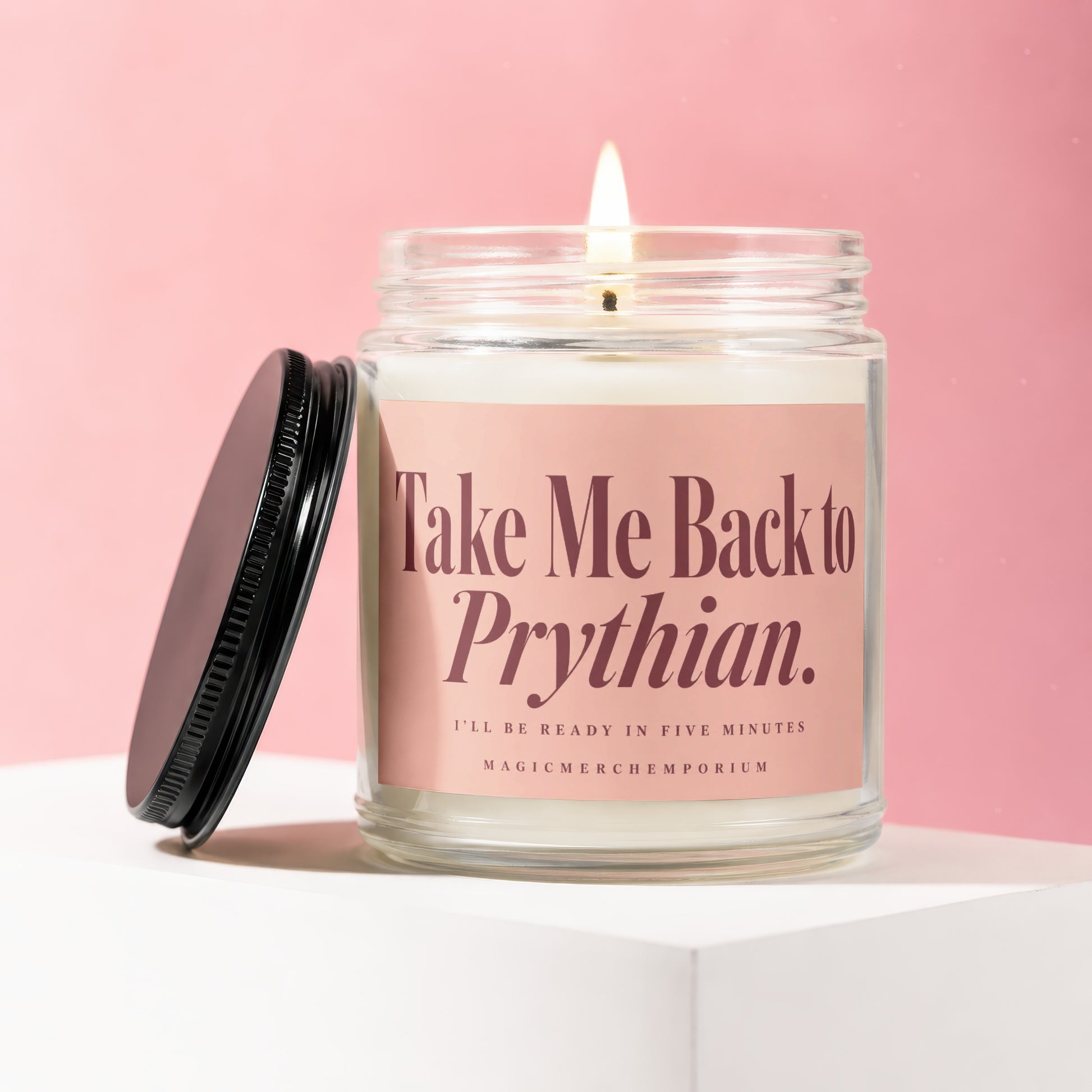 Lit candle in a jar with a pink label reading "Take Me Back to Prythian."