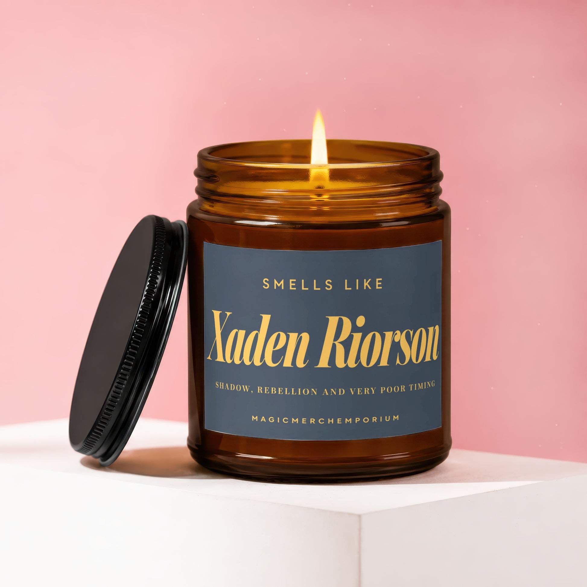 Amber jar candle with lit wick, dark blue label says "Xaden Riorson"