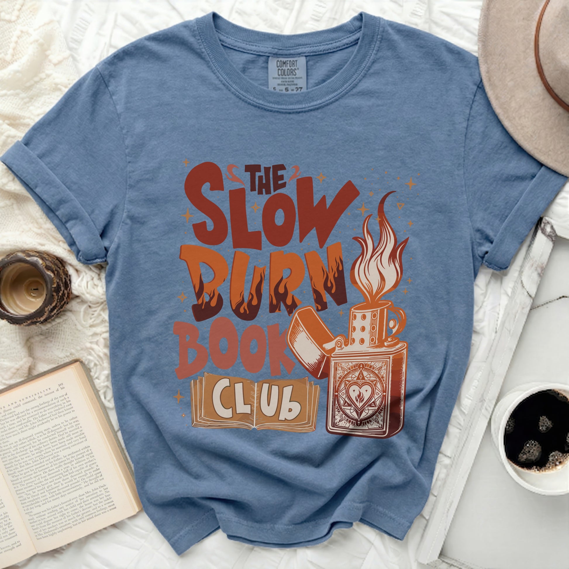Blue t-shirt with "The Slow Burn Book Club" graphic and a lighter.