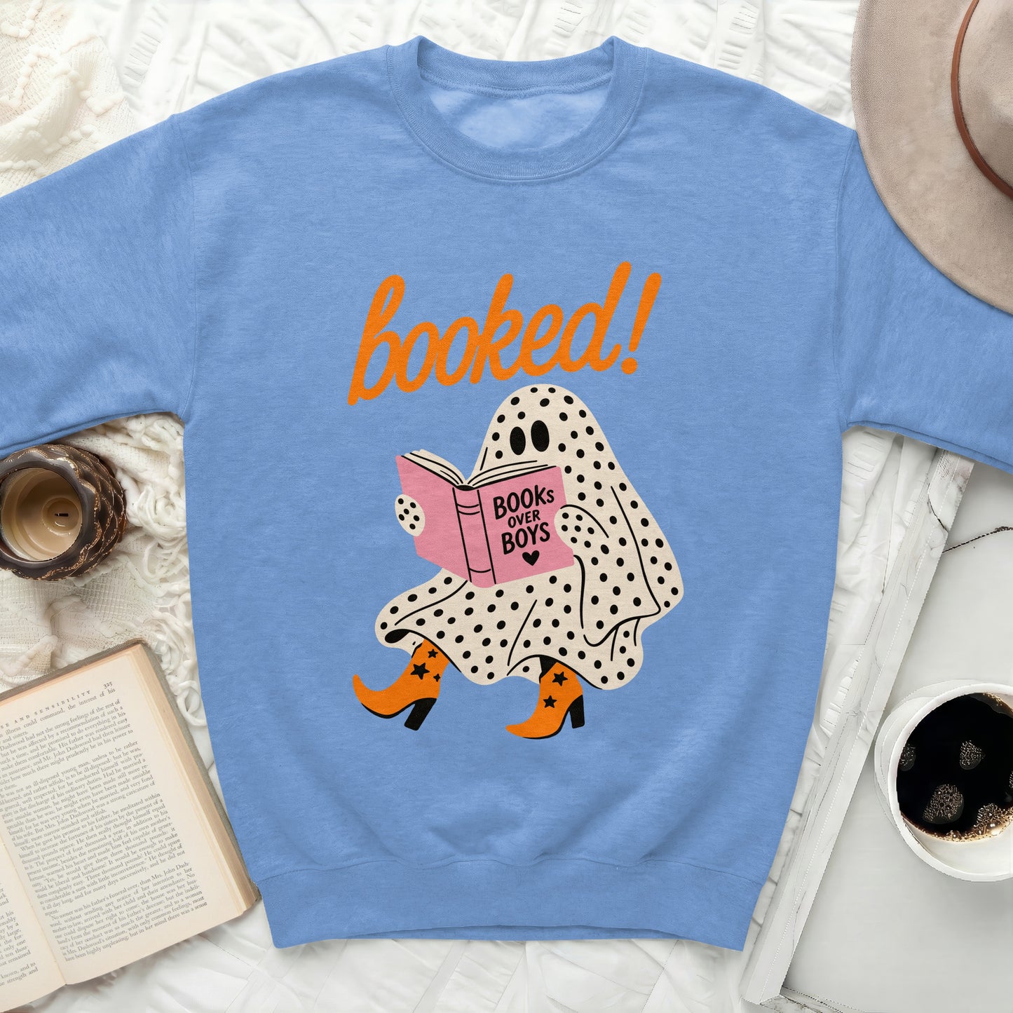 Light blue sweatshirt with a graphic of a ghost reading and text "booked!".