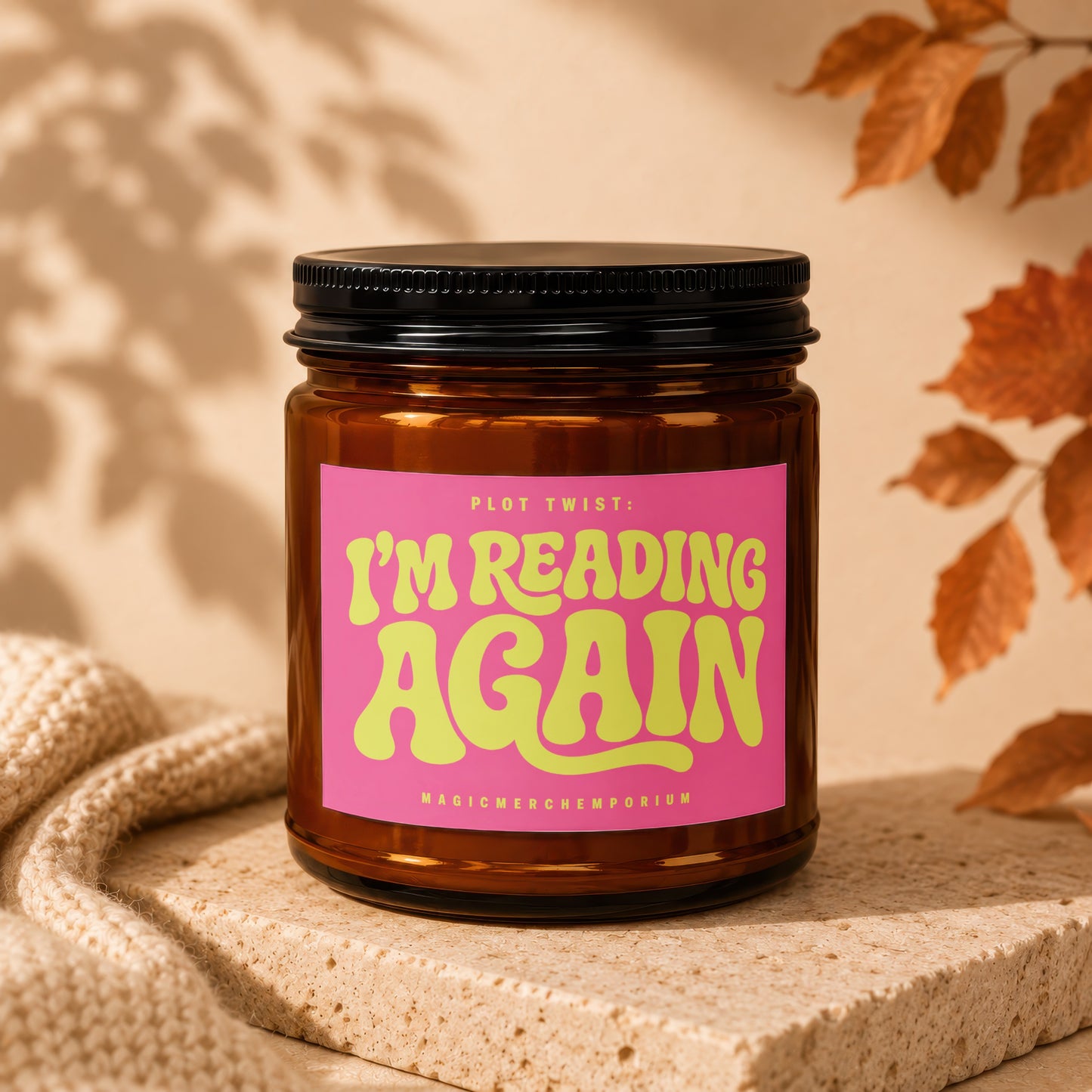 Amber jar candle with pink label reading "Plot Twist: I'm Reading Again."