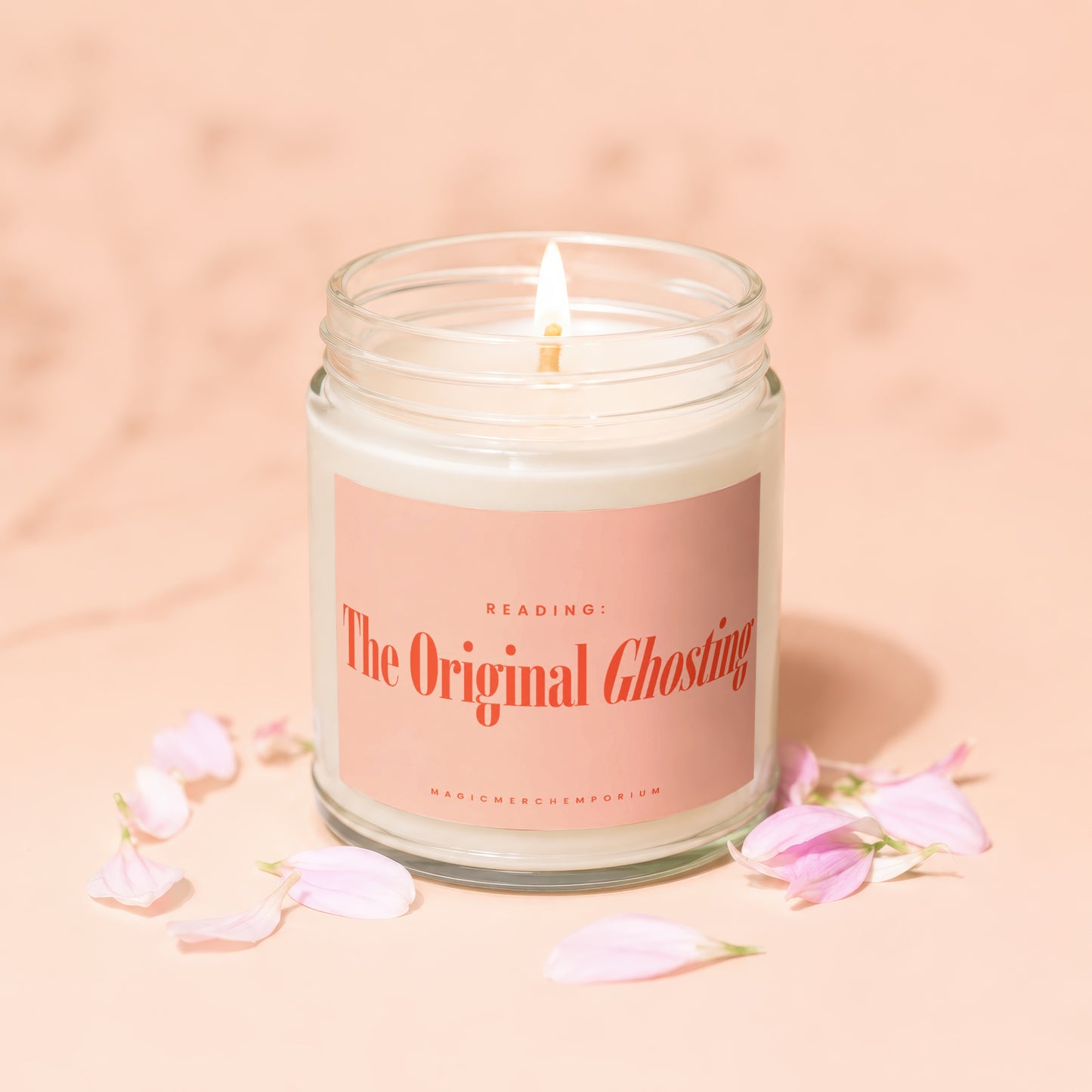 White candle in a glass jar with pink label that reads "The Original Ghosting" and "MAGICMERCHEVMPORIUM".