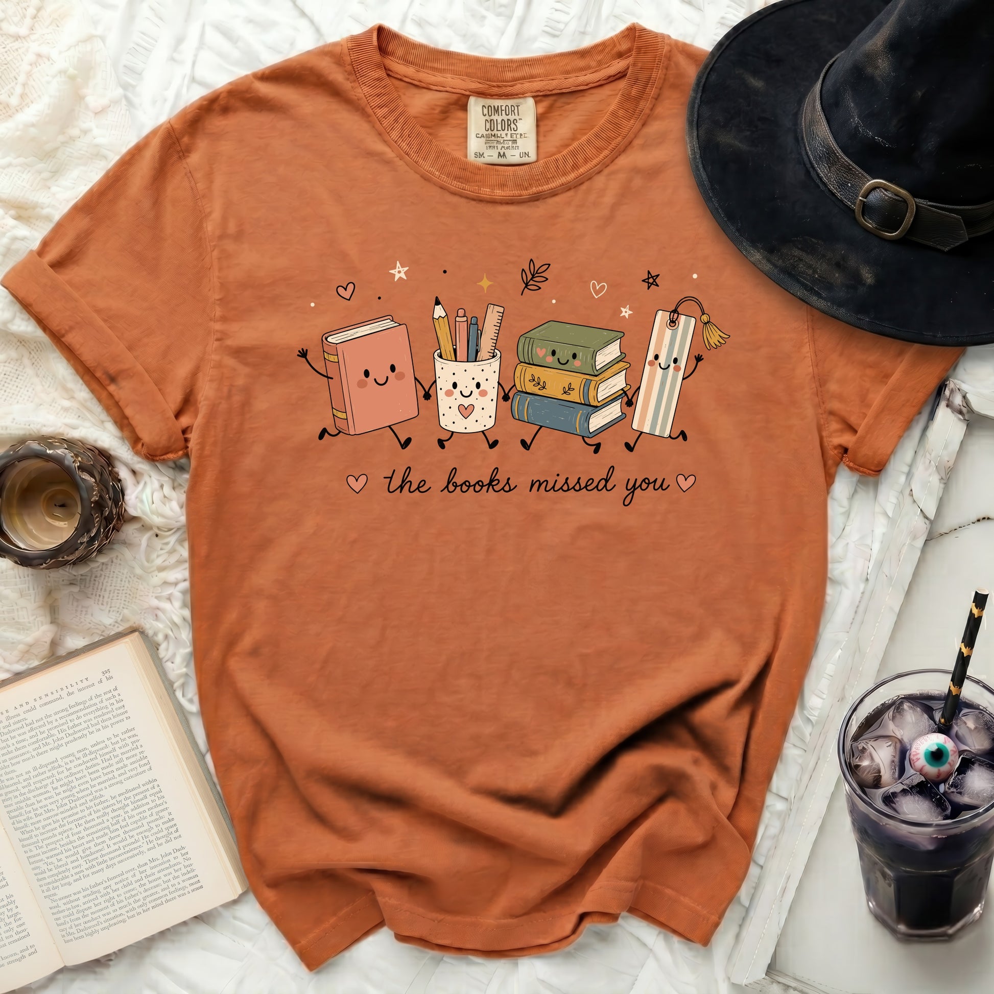 Orange t-shirt with animated books and school supplies that say "the books missed you".