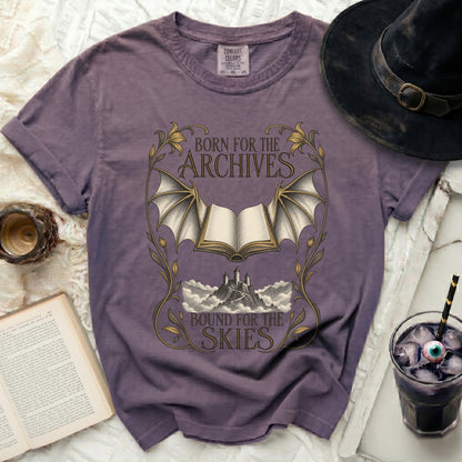Purple t-shirt with "Born for the Archives, Bound for the Skies" text and fantasy art.