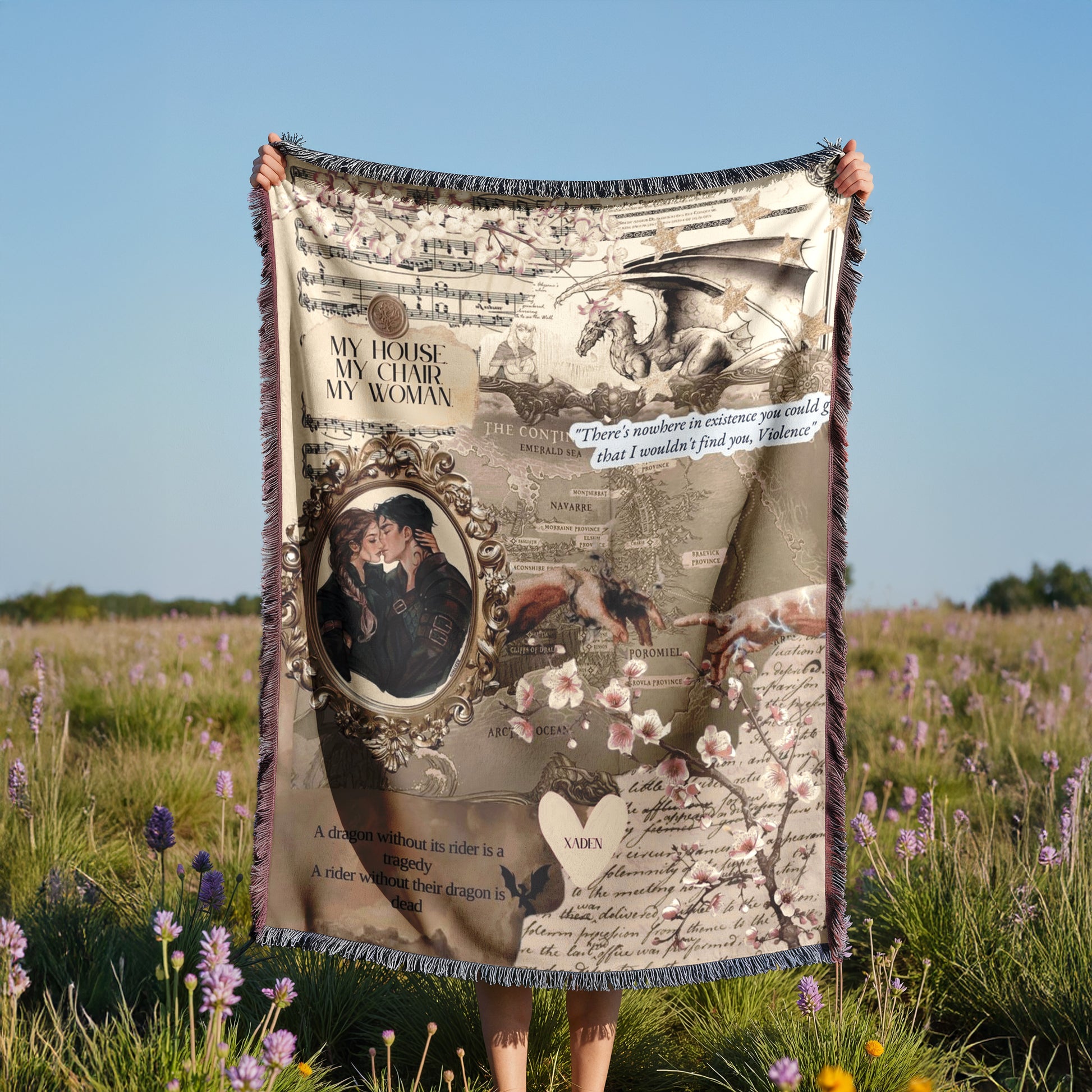 A person is holding up a blanket with a collage of various images, including a couple embracing, a dragon, and a map. The blanket also contains text and a heart symbol.