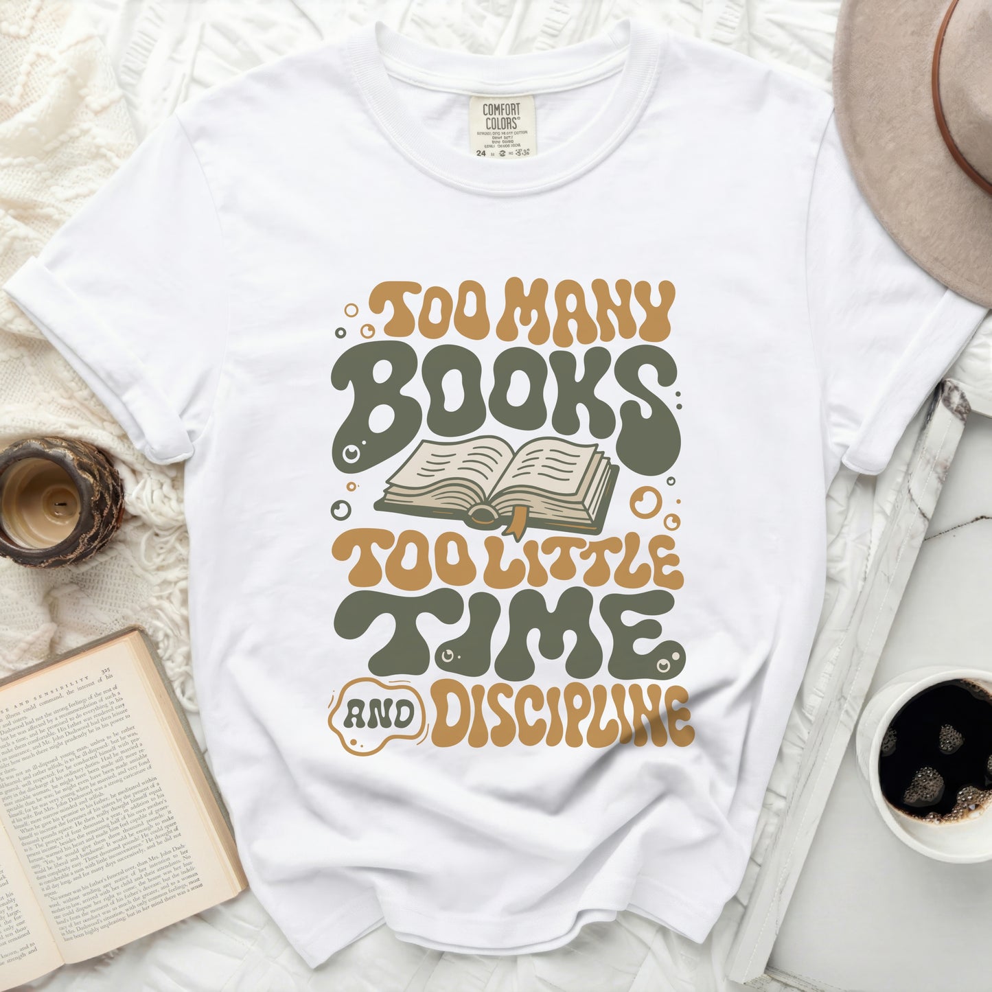 White t-shirt with "Too Many Books Too Little Time and Discipline" graphic design.