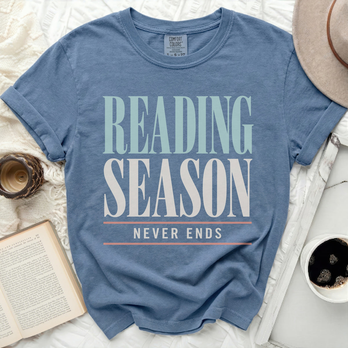 Blue t-shirt with "Reading Season Never Ends" text, book, and coffee.