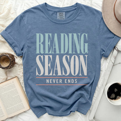 Blue t-shirt with "Reading Season Never Ends" text, book, and coffee.