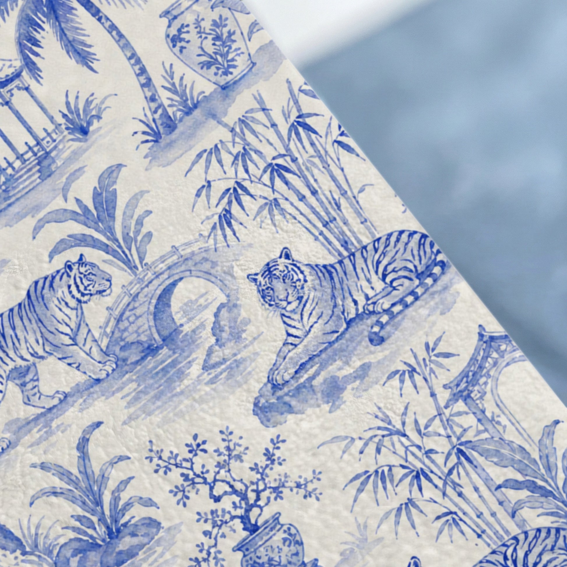 Blue and white toile pattern with tigers, bamboo, and architecture.