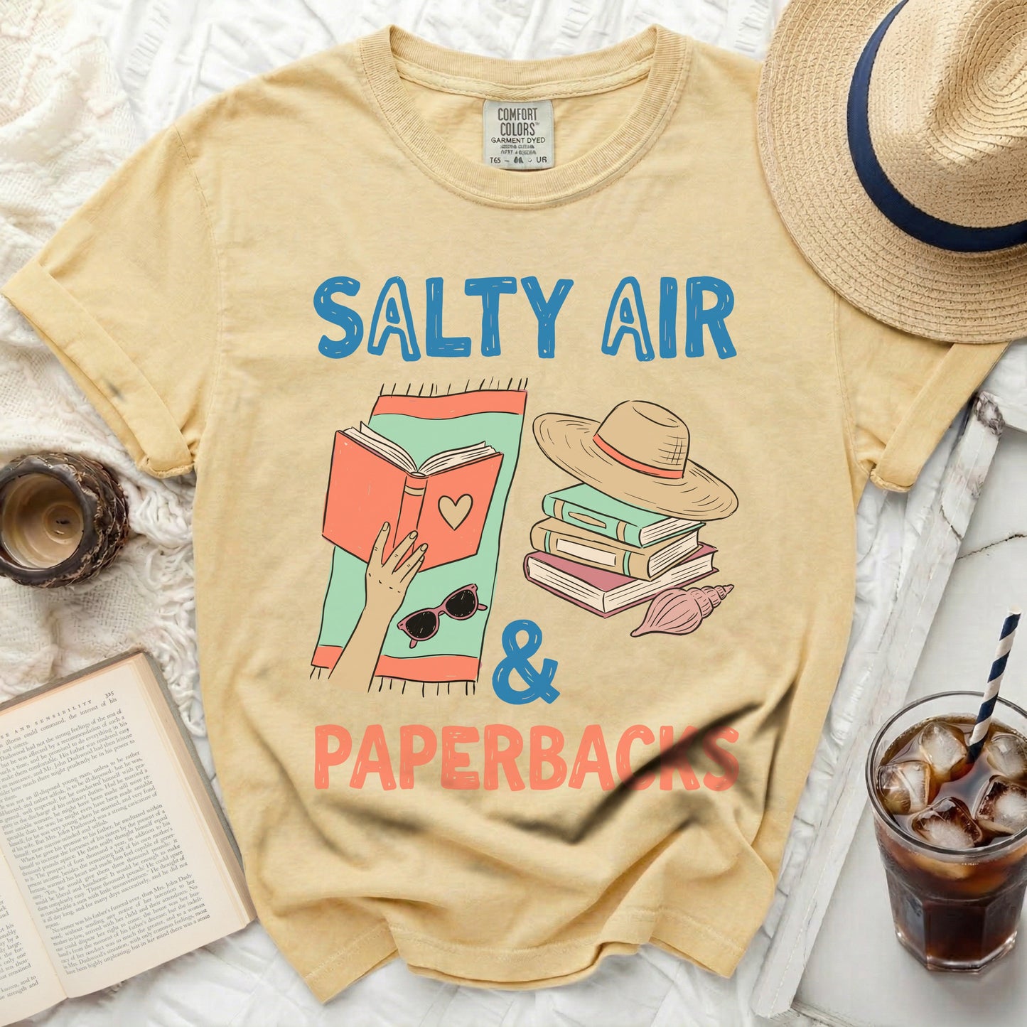 Yellow t-shirt with "Salty Air & Paperbacks" text and book graphics.