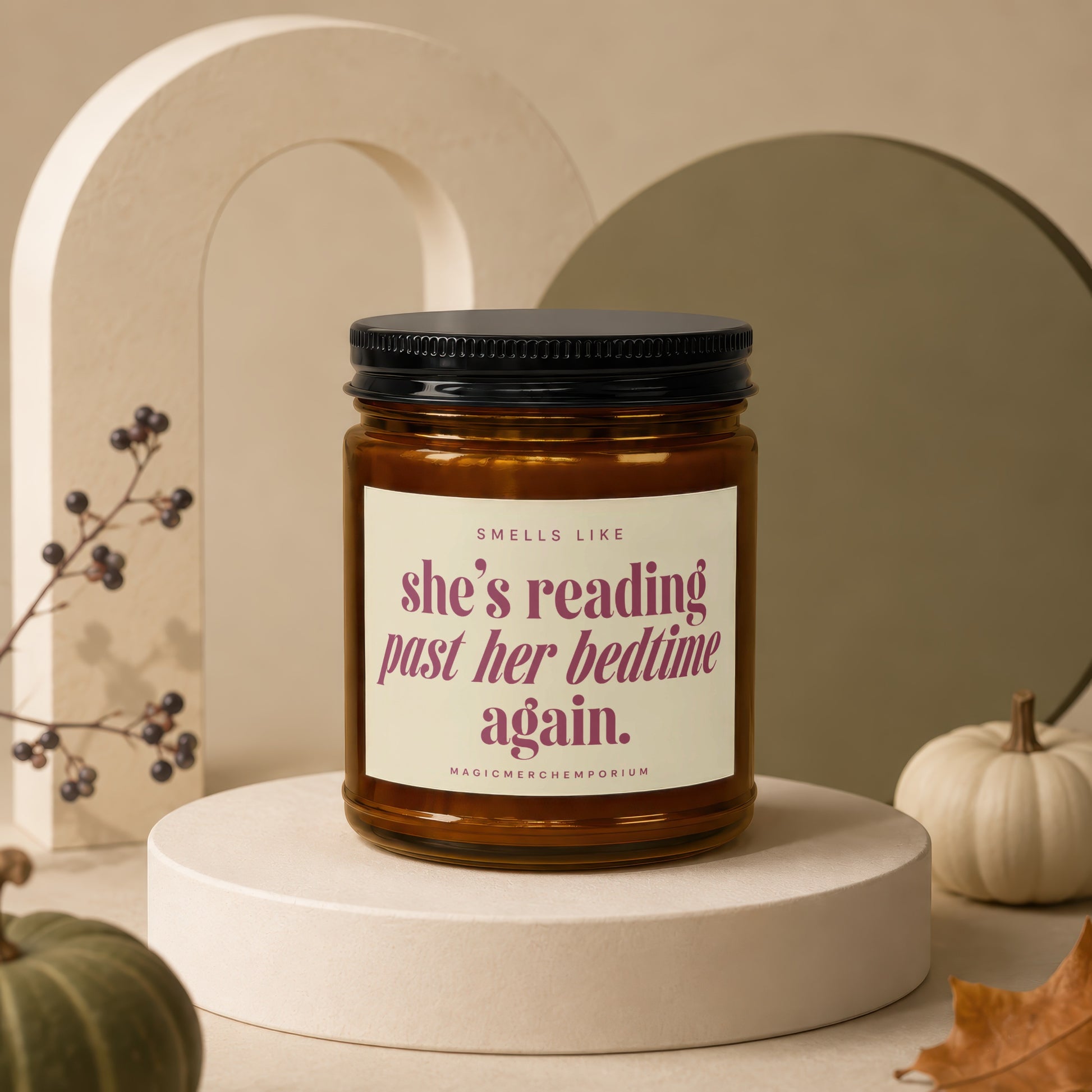 Amber candle with black lid, "she's reading past her bedtime again." text.