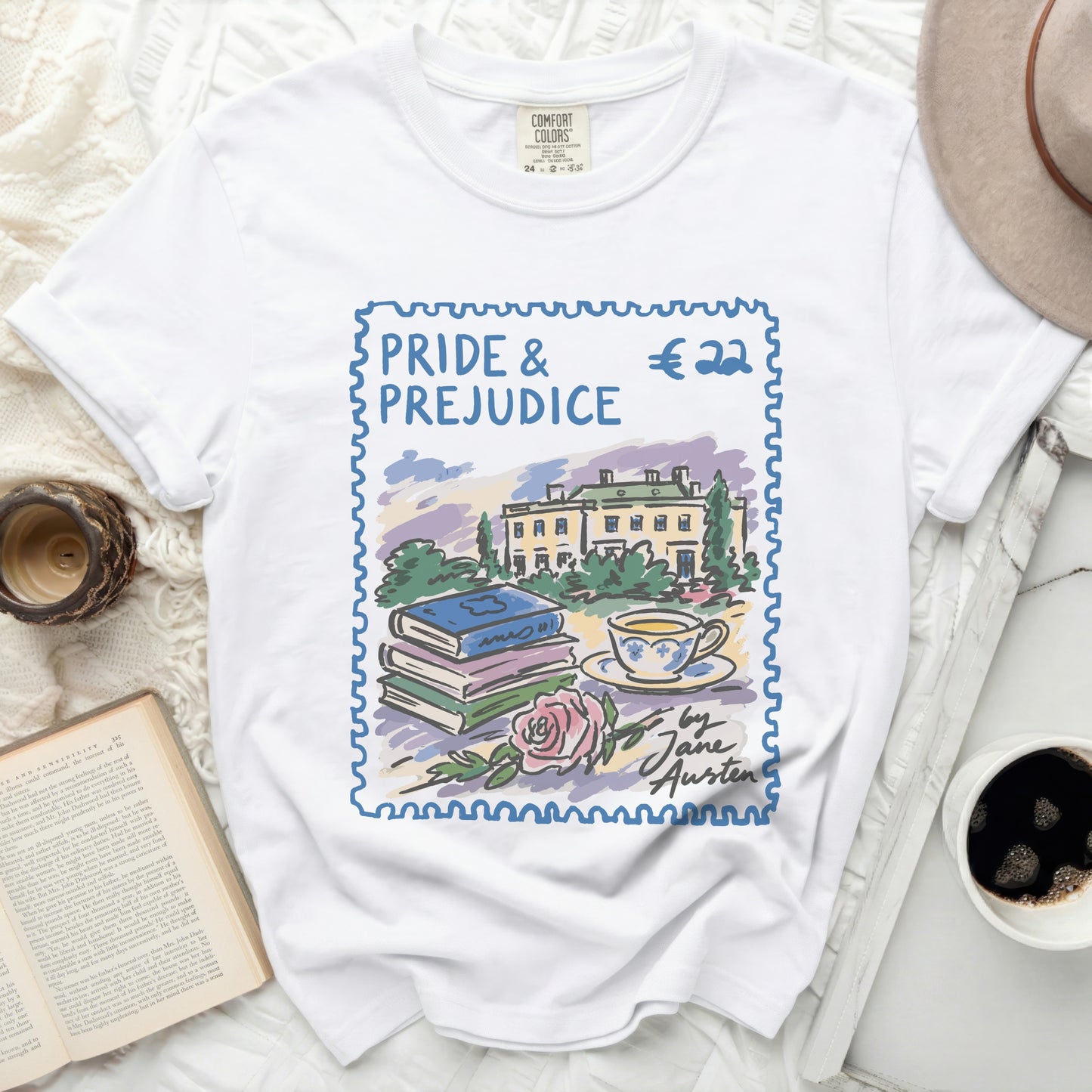 White t-shirt with a stamp design of Pride & Prejudice, books, teacup, and rose.