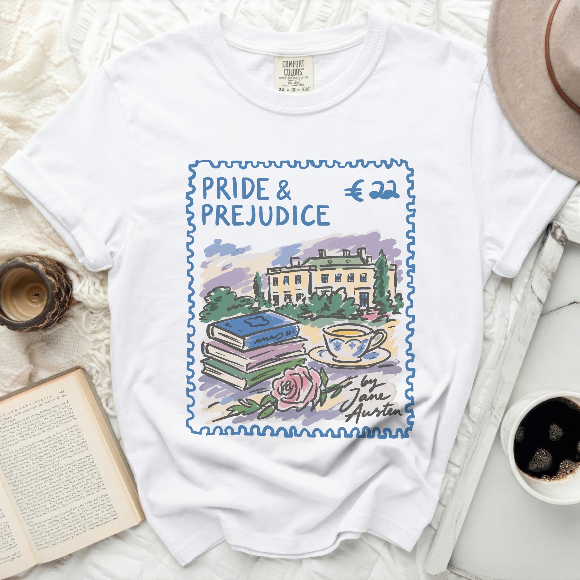 White t-shirt with a stamp design of Pride & Prejudice, books, teacup, and rose.
