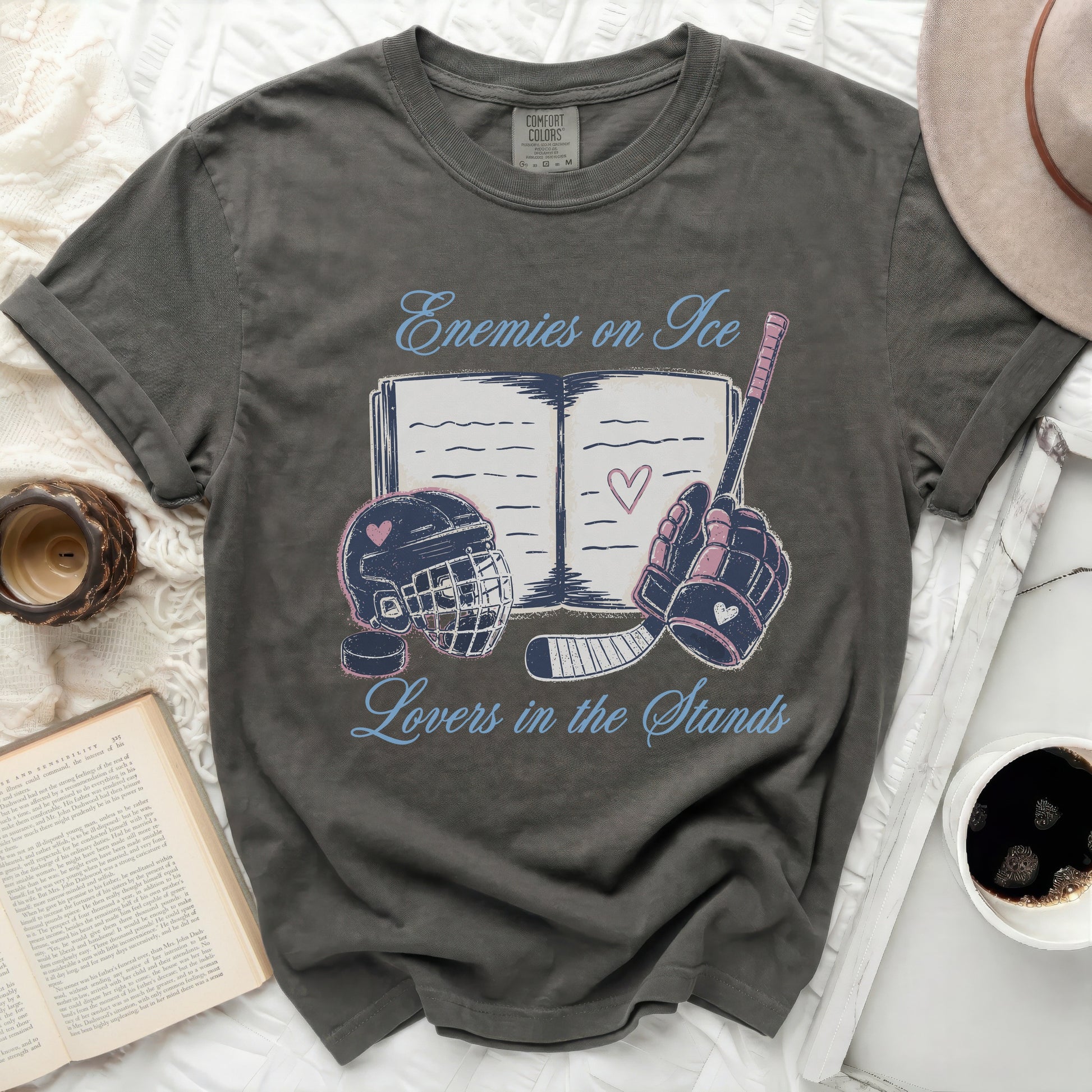Dark gray t-shirt with "Enemies on Ice Lovers in the Stands" text and hockey graphics.