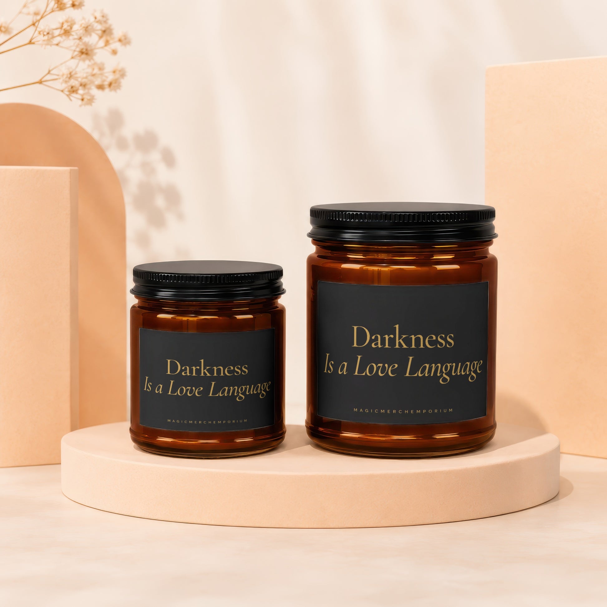 Two amber glass jars with black lids, one larger than the other, feature black labels with gold text.