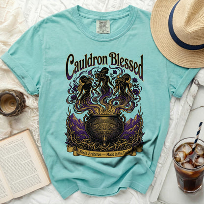 Teal t-shirt with "Cauldron Blessed" and witches graphic, text "Nesta Archeron – Made in the Dark".