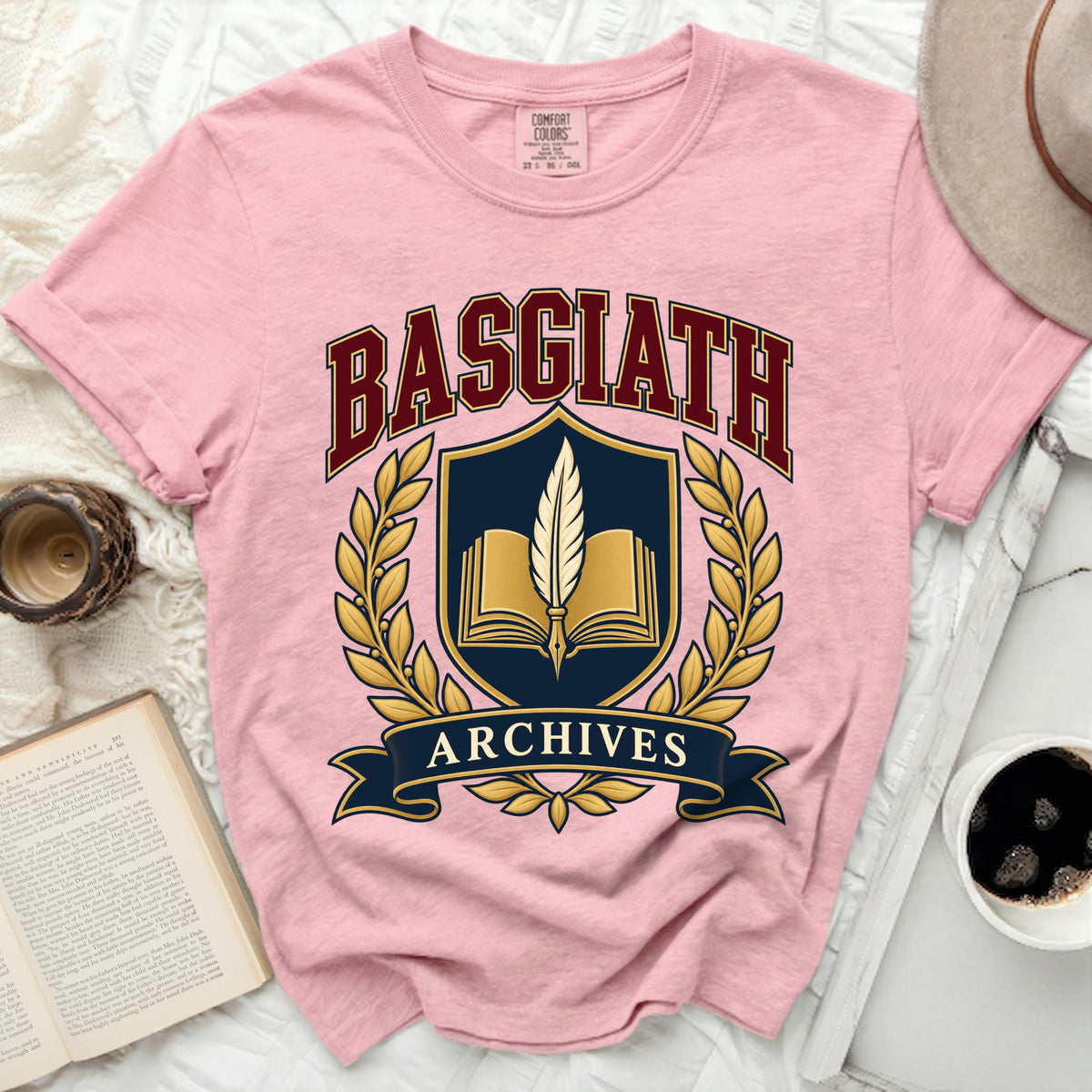 Pink t-shirt with "BASGIATH ARCHIVES" text and book and feather emblem.