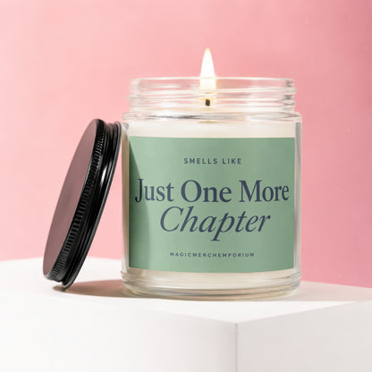 Candle in a glass jar with a black lid, labeled "Just One More Chapter".