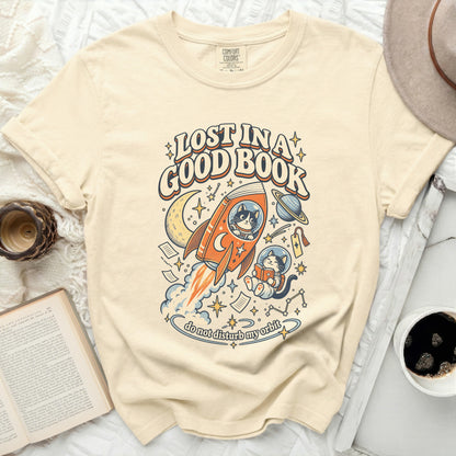 Cream t-shirt with "Lost in a Good Book" text and graphic of cats in space.