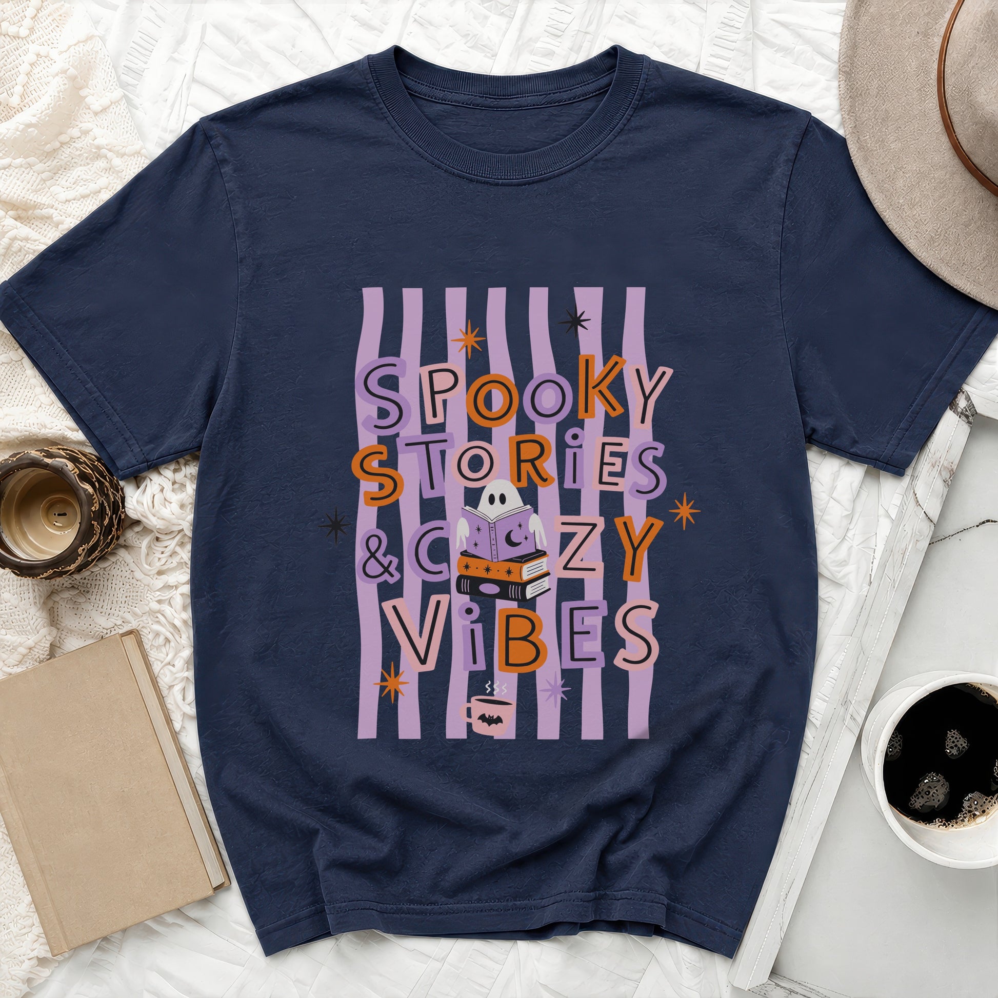 Navy t-shirt with "Spooky Stories & Cozy Vibes" text and Halloween graphics.