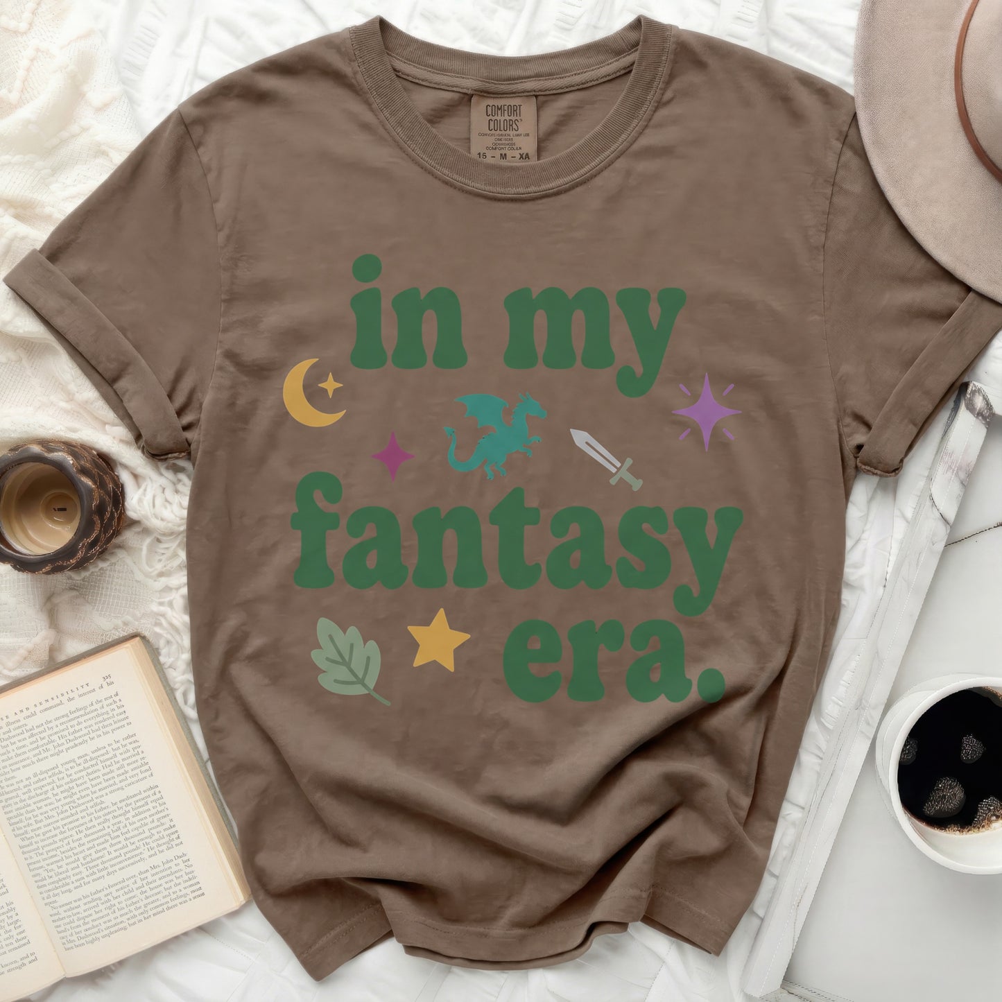 Brown t-shirt with "in my fantasy era" and fantasy icons.