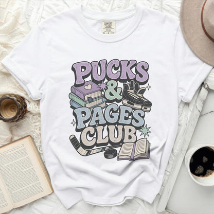 White t-shirt with "Pucks & Pages Club" graphic, books, and hockey skates.