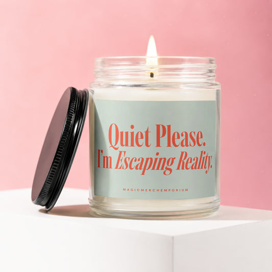 Candle with text "Quiet Please. I'm Escaping Reality." against pink background.