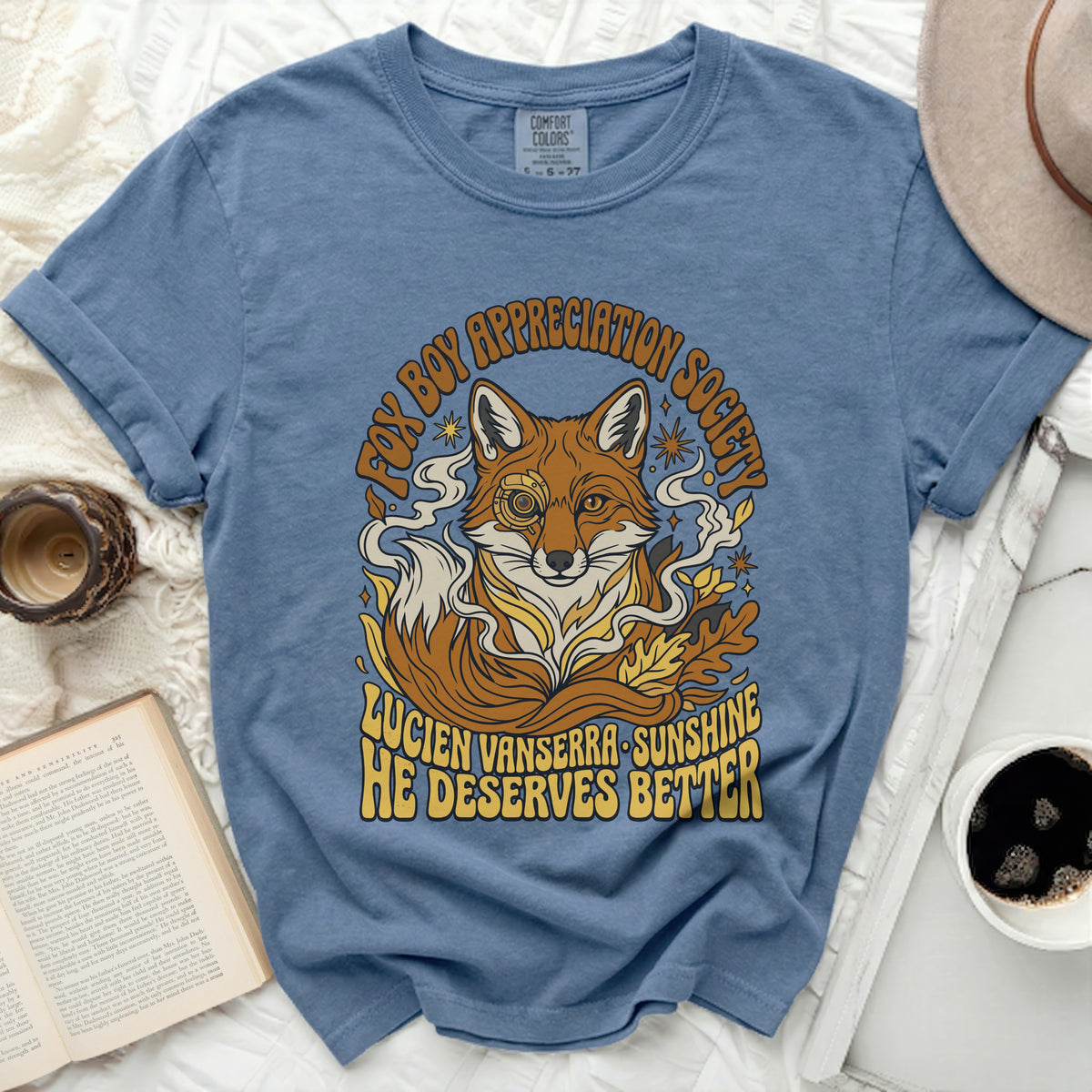 Blue t-shirt with a stylized fox and text "FOX BOY APPRECIATION SOCIETY" and "LUCIEN VANSERRA SUNSHINE HE DESERVES BETTER".