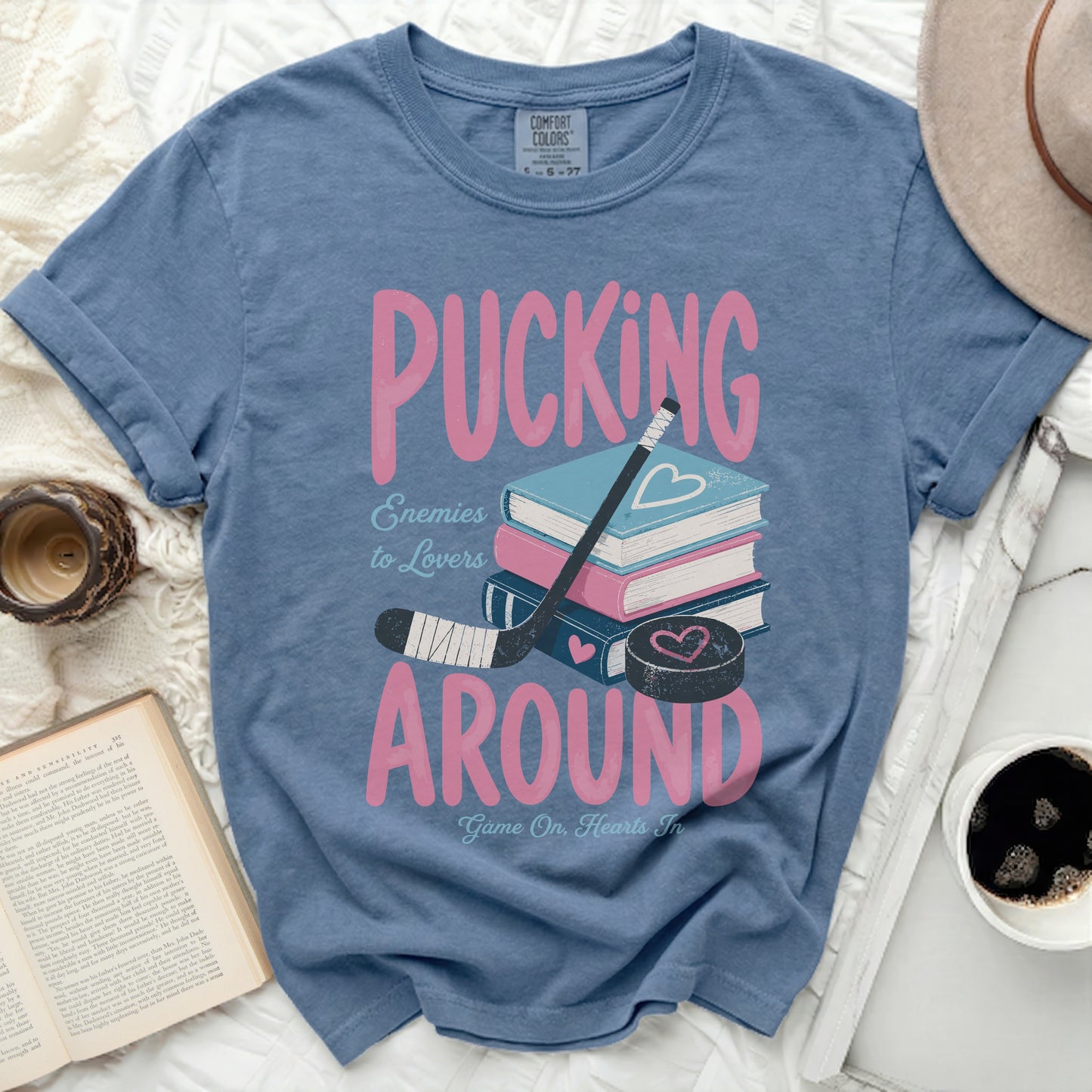 Blue t-shirt with "Pucking Around Enemies to Lovers" and hockey puck.