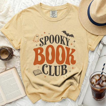 Yellow t-shirt with "Spooky Book Club" text, ghost, bat, and book graphics.