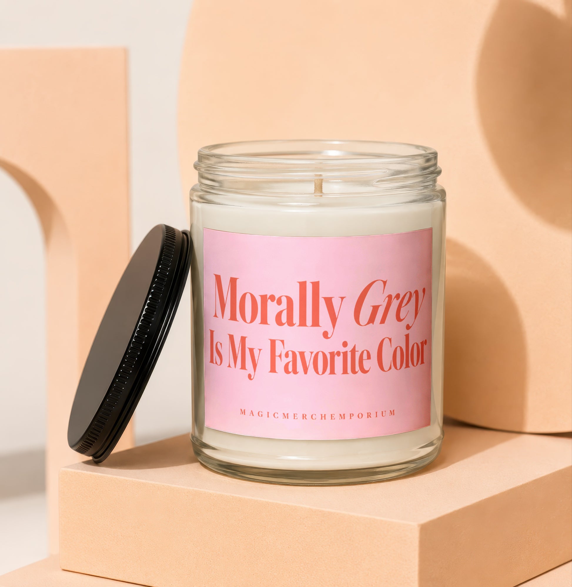 Glass candle with pink label reading "Morally Grey Is My Favorite Color".