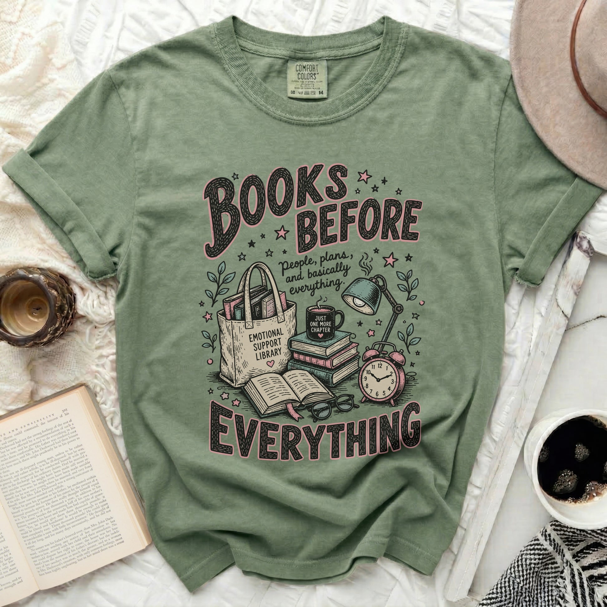 Olive green t-shirt with "Books Before Everything" graphic and reading accessories.