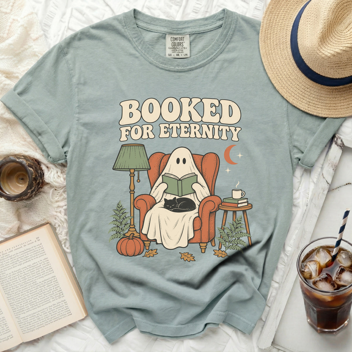 Ghost reading a book with a cat, text "BOOKED FOR ETERNITY".