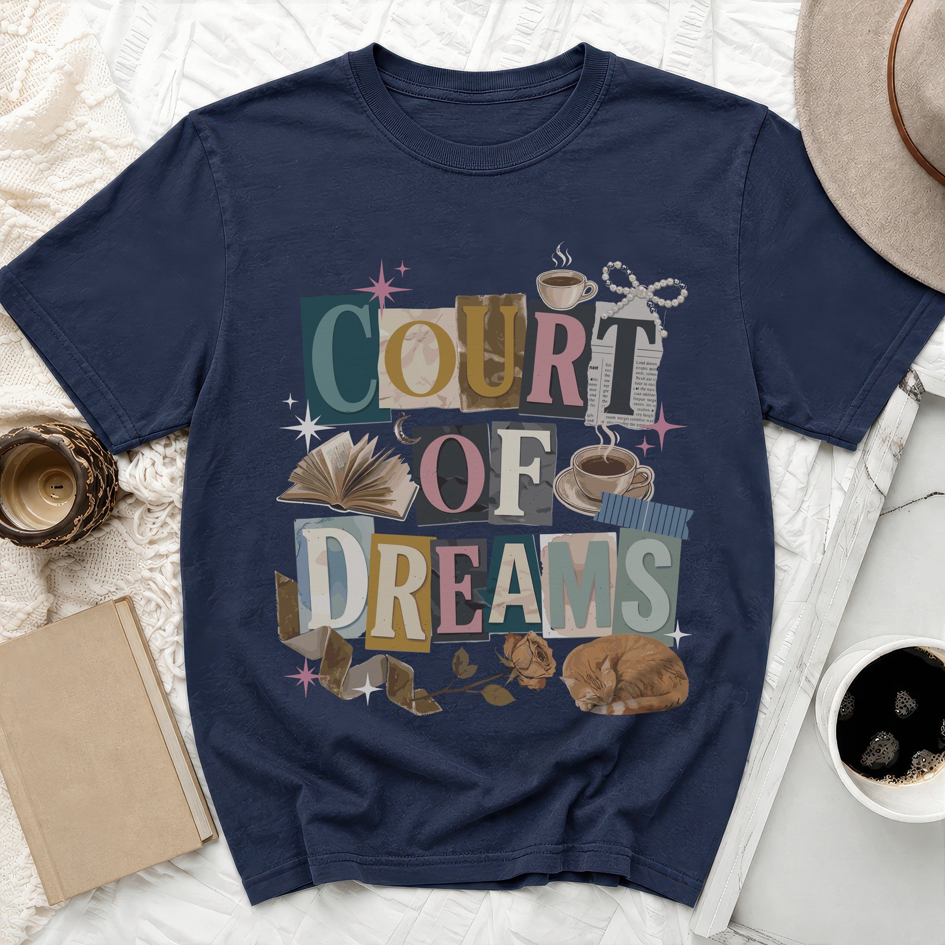 Navy t-shirt with "COURT OF DREAMS" text collage and illustrated elements.