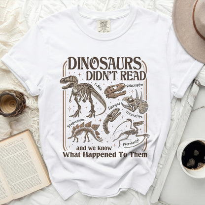 White t-shirt with brown graphic of dinosaur skeletons and text.