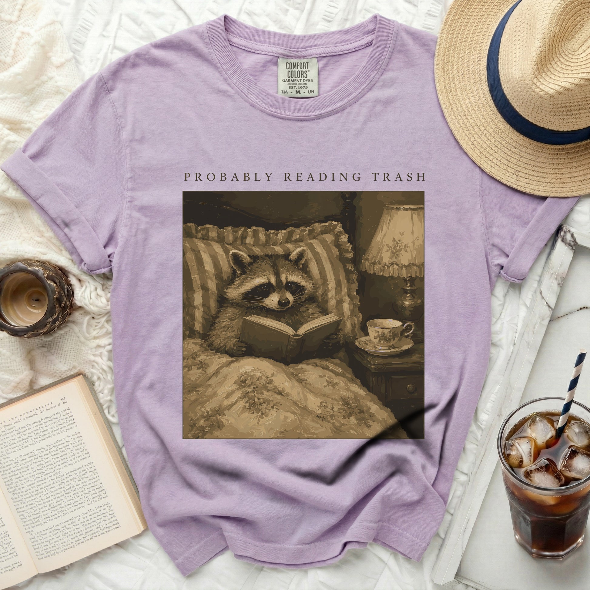 Purple t-shirt with raccoon reading "Probably Reading Trash" graphic.