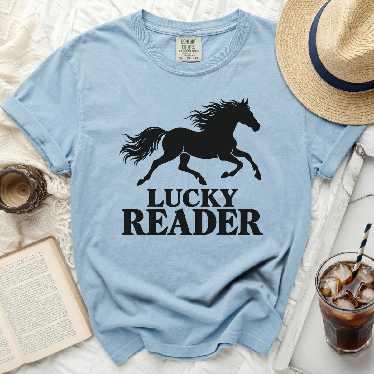 Light blue t-shirt with black silhouette of a running horse and text "LUCKY READER".