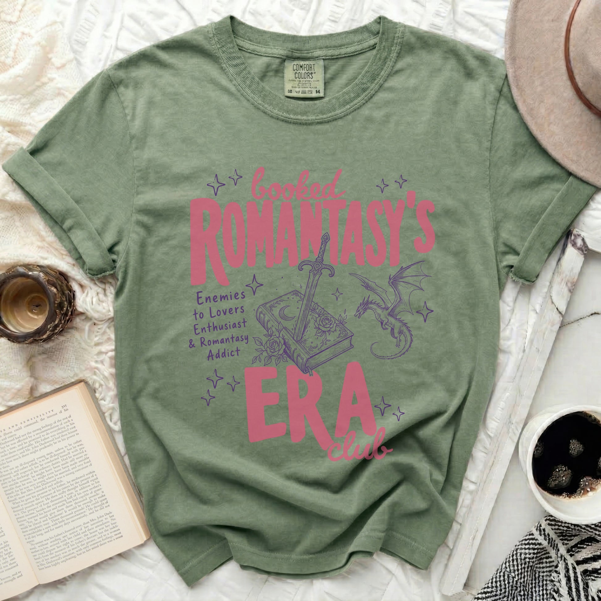 Green t-shirt with pink text and graphics: "booked ROMANTASY'S ERA club"